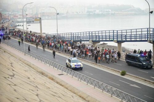 Police officers and Spanish soldiers escort a big group of migrants to the border to take them out of Spain, after mass crossings of migrants on foot and by sea from Morocco into Spanish territory, in Ceuta, Spain, August 1, 2026. REUTERS/Fabian Bimmer