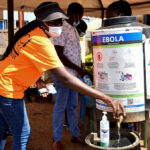 FILE PHOTO: A medical worker controls the sanitization point for travellers to wash their hands before entering the Kenya immigration services to access port health services at the Busia One Stop Border Post, crossing-point between Kenya and Uganda, after a man who had been living in the Democratic Republic of Congo travelled and died of a new Ebola outbreak involving the Bundibugyo species at the Nairobi Hospital, in Busia, Kenya October 8, 2026. REUTERS/James Keyi/File Photo